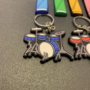 Macro shot of 3D PVC drum set and guzheng musical instrument keychain details