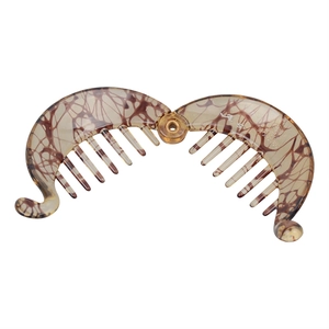 Detailed view of an open amber tortoiseshell banana hair clip with metal hinge and teeth