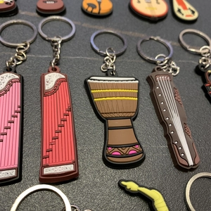 Close-up of colorful PVC keychains featuring Chinese musical instruments like Guzheng and Ruan