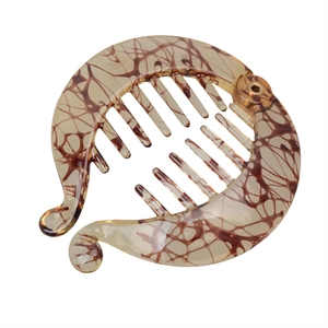 Detailed view of banana hair clip featuring amber resin texture and sturdy interlocking teeth