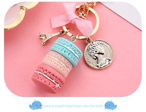 Detailed close-up of a 3-tier macaron keychain with Eiffel tower and silk bow charm