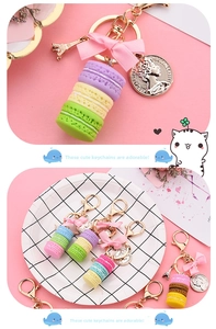 Detailed close-up of macaron cake keychain with pink bow and golden Eiffel Tower charm