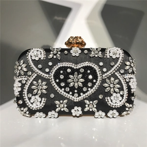 Detail of beaded evening clutch with pearl heart pattern and floral gold clasp