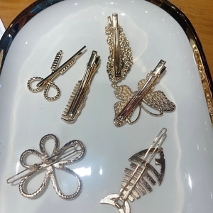 Golden hair clip set featuring creative shapes like scissors, combs, and butterflies