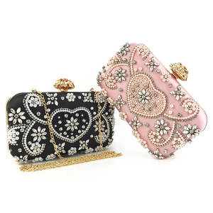 Detail of beaded evening bag featuring heart pearl patterns and diamond rose clasp