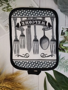 Thick cotton pot holder with monochrome patterns, hanging loop, and texture detail