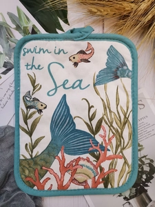 Macro detail of nautical cotton trivet with blue trim and ocean life pattern
