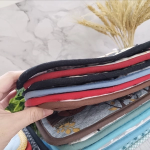 Close-up of stacked thick quilted cotton trivets and heat-resistant kitchen pads in multiple colors