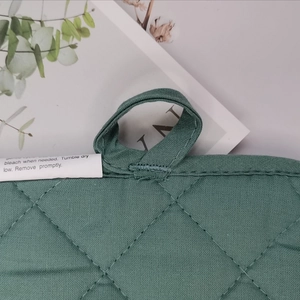 Detailed close-up of quilted cotton heat insulation mat with hanging loop and seam detail