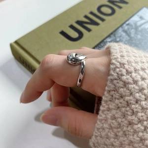 Detail of minimalist 925 sterling silver irregular water drop ring worn on index finger