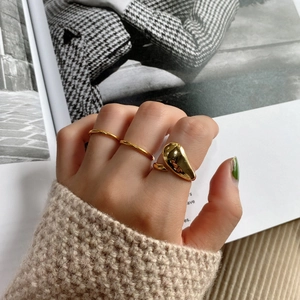 Detailed close-up of 925 silver irregular teardrop gold ring set on model hand