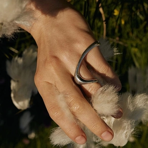 French style 925 sterling silver irregular liquid ring on hand in natural sunlight