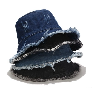 Distressed denim bucket hats with frayed edges in blue and black colors