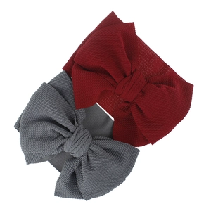 Detail of baby headband with waffle texture knit fabric and large bow in burgundy and grey