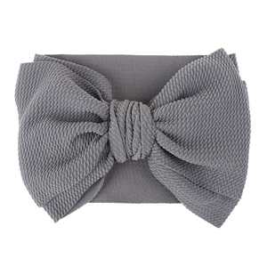 Detail showing grey waffle knit texture on infant bow headband with soft elastic fabric