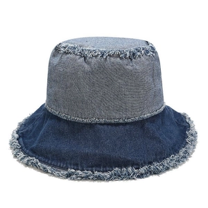 Détail des bords effilochés d'un chapeau bob en denim bicolore avec franges