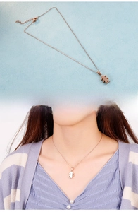 Vue détaillée d'un pendentif fille de dessin animé en or rose sur un collier en acier