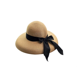 Women's summer straw beach hat with wide brim and black ribbon bow in khaki color