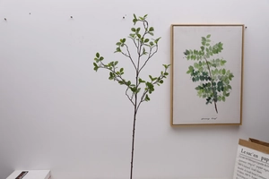 Detailed view of artificial Milan leaves on a slender brown stem for home decoration