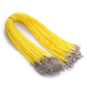 Close-up of yellow waxed cord necklaces with silver lobster clasps and extension chains