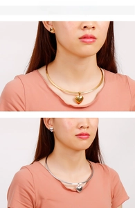 Detail view of heart pendant necklace and stud earring set in gold and silver finishes
