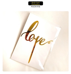Mirror gold love acrylic cake topper shown in carded protective plastic packaging