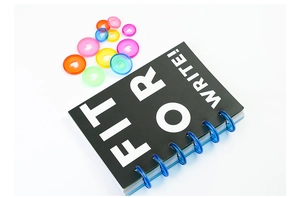 Close-up of black disc-bound notebook with Fit For Write text and colorful heart rings