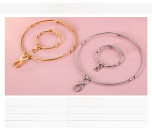 Detail of stainless steel infinity symbol necklace and bracelet set in gold and steel finishes