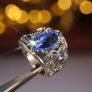 Macro shot of large marquise-cut blue crystal ring with silver leaf filigree details