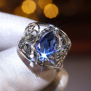 Macro shot of silver filigree ring featuring a large marquise cut blue crystal