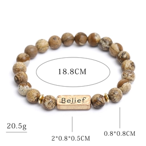 Natural stone bracelet with gold Belief charm and wood grain beads on white background