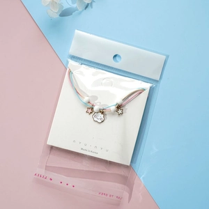 Detail of Korean braided bracelet with star and cloud charms in OPP bag packaging