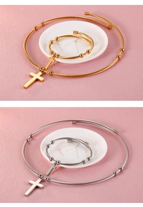 Détail de parures de bijoux chaîne câblée or et argent avec croix et perles métalliques