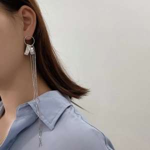 Detail of 925 sterling silver tassel earrings with meteorite texture on a model