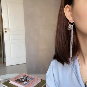Close-up of 925 sterling silver tassel drop earrings worn by a model in a minimal setting