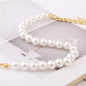 Close-up of white Baroque pearls with a gold-plated lobster clasp and extension chain