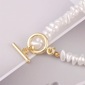 Close-up of baroque pearl bracelet with elegant gold OT toggle clasp on silk fabric
