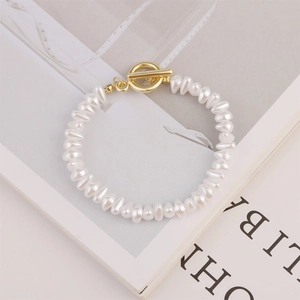 Macro detail of irregular baroque pearl bracelet with elegant golden T-toggle clasp