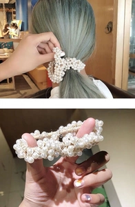 Detailed view of elastic hair ring made of multiple cream white lustrous pearls