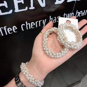 Elegant white pearl hair tie elastic band shown on hand with high gloss texture