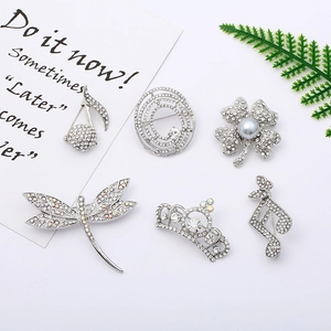 Detailed view of silver-plated brooch set with sparkling rhinestones and grey faux pearl