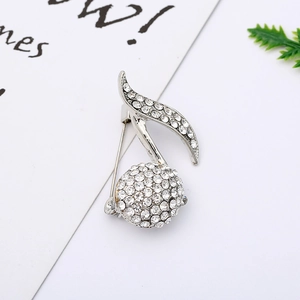 Macro shot of silver music note brooch with sparkling rhinestones on white background