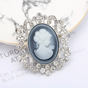 Detailed macro view of vintage cameo brooch with white relief and crystal accents