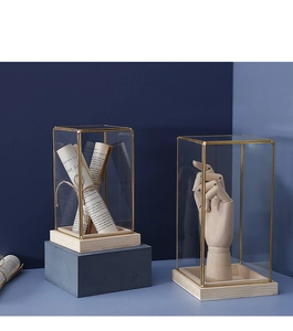 Detail of vintage glass display case with gold metal frame and solid wood base