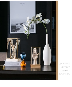 Artistic Nordic decor with glass cloche, ceramic orchid vase and modern hourglass