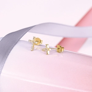 Detail shot of golden S925 sterling silver cross earrings with sparkling rhinestones