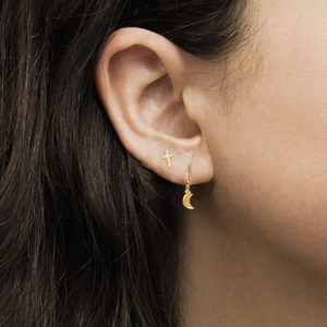 Close-up of gold S925 silver cross stud with diamonds and moon earring on ear