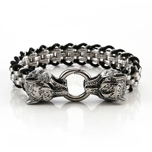 Detailed close-up of double wolf heads on a black braided leather punk style bracelet