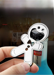 Close-up of metal gingerbread man bottle opener being used to open a bottle cap