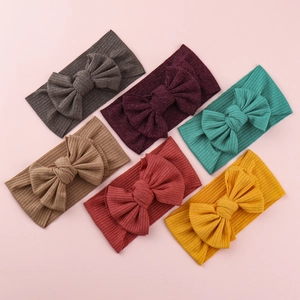 Set of six colorful knitted baby headbands with large bows in soft ribbed fabric